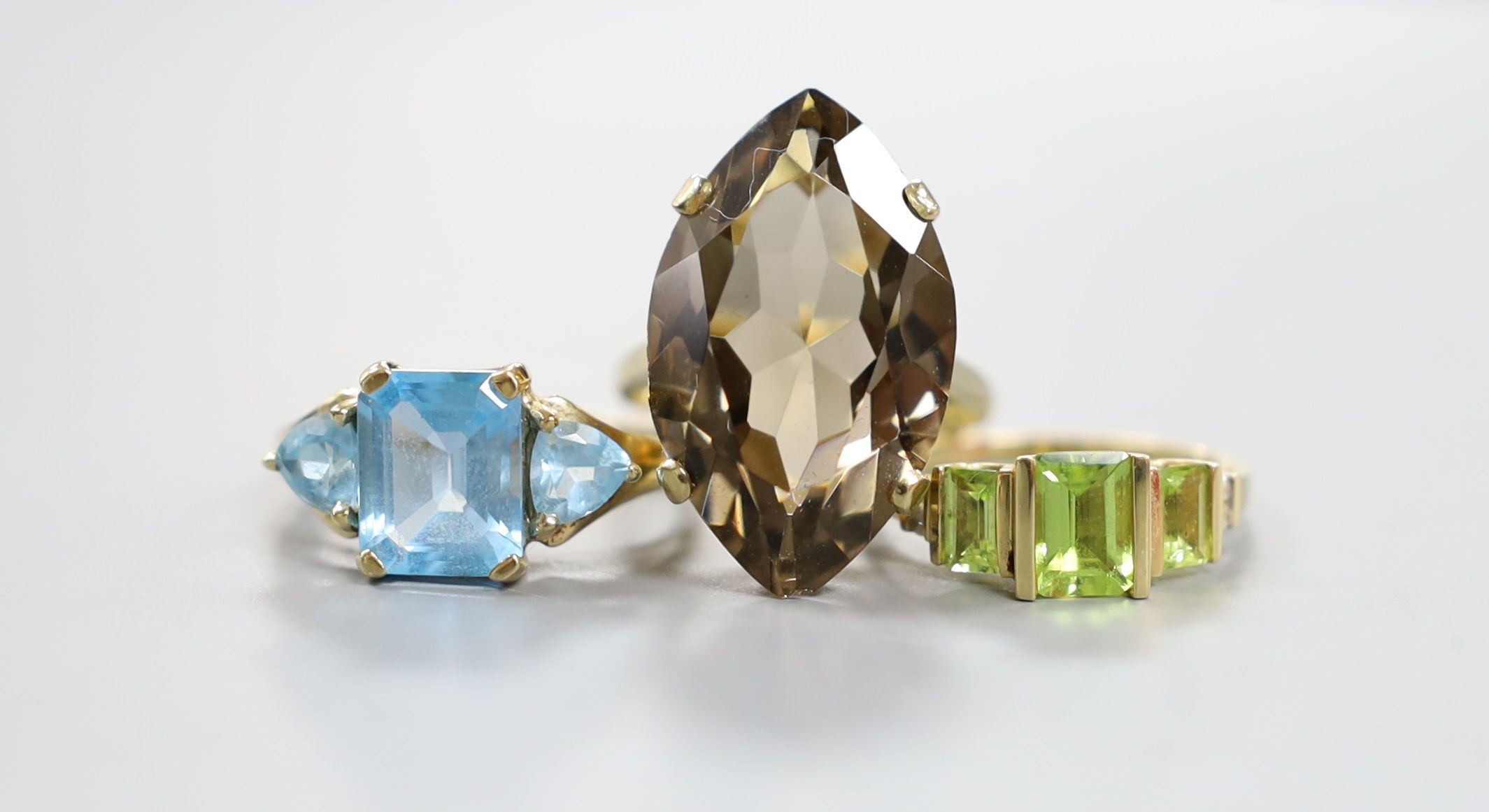 A modern 9ct gold and quartz set dress ring, gross 7.5 grams, a 10k and gem set ring, gross 3 grams and a 14k and gem set ring, gross 3.3 grams.
